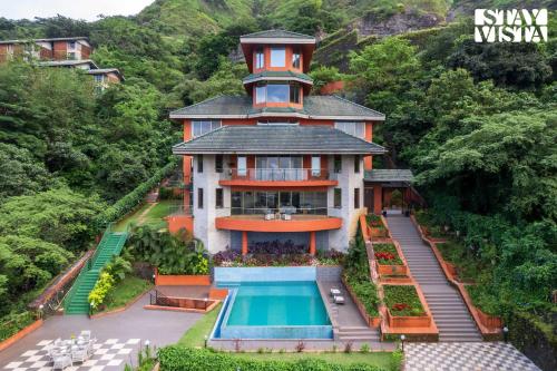 a house with a swimming pool in front of it at StayVista at Airhill with Pool, Bonfire, WiFi in Lonavala