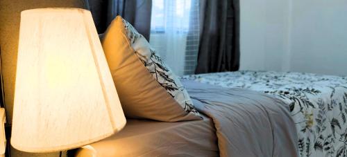 a bed with a pillow and a lamp on it at Ormoc City Gate 4 in Batog