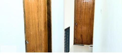 two wooden doors in a room with a bathroom at Ormoc City Gate 4 in Batog
