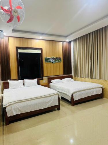 a bedroom with two beds and a ceiling fan at Bình Minh Hotel Pleiku in Pleiku