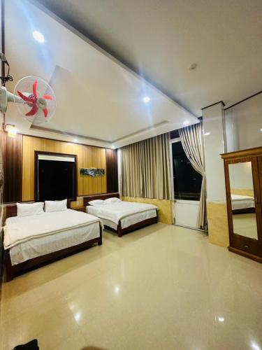 a hotel room with two beds and a fan at Bình Minh Hotel Pleiku in Pleiku
