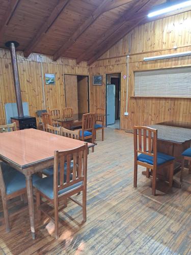 a dining room with wooden tables and chairs at Hospedaje Casa Betalpu in Culenar