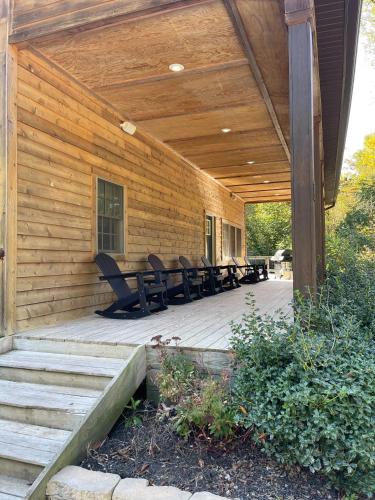 a wooden deck with benches on a house at Pine Creek Cabins & Camping Resort in South Bloomingville