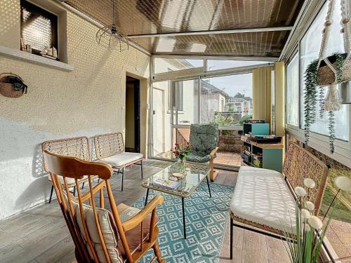 - une véranda avec des chaises et une table dans l'établissement Maison rénovée avec jardin, garage, parking et WiFi gratuit - FR-1-361-558, à Granville