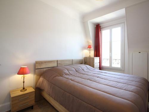 une chambre avec un grand lit et une fenêtre dans l'établissement T2 Confortable avec WiFi proche thermes - FR-1-608-274, à La Bourboule