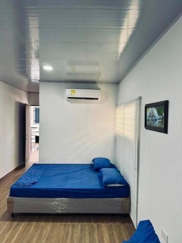 a bedroom with a bed with blue pillows on it at Hostal tercer cielo Restaurante Fidelio in Santa Marta