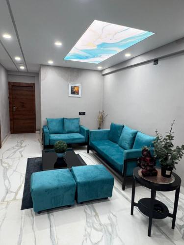 a living room with blue couches and a skylight at Wild Wings Premium Hotel in Hyderabad