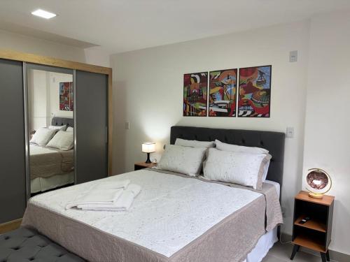 a bedroom with a large bed and a mirror at Studio próximo Museu do Amanhã in Rio de Janeiro