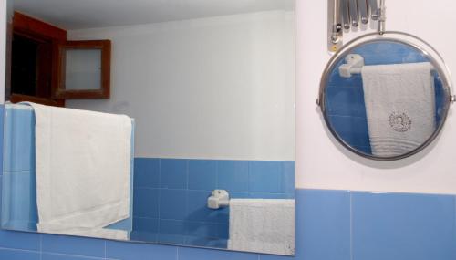 a blue and white bathroom with a mirror and towels at Olmitos 3, Casa-Palacio Real Piedad in Cehegín