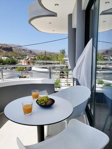 a table with a bowl of fruit on a balcony at Phaedra's Studios in Kolymbari in Chania Town