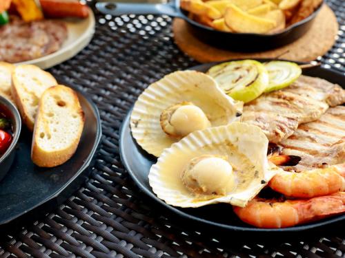 a table with a plate of food with seafood and bread at HARIO Beach Walk in Sakihario