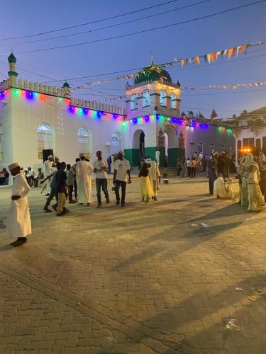Un gruppo di persone che ballano di fronte a un edificio di Subira House a Lamu