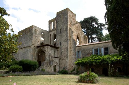 an old stone building with a tower at Abbaye De Villelongue in Saint-Martin-le-Vieil