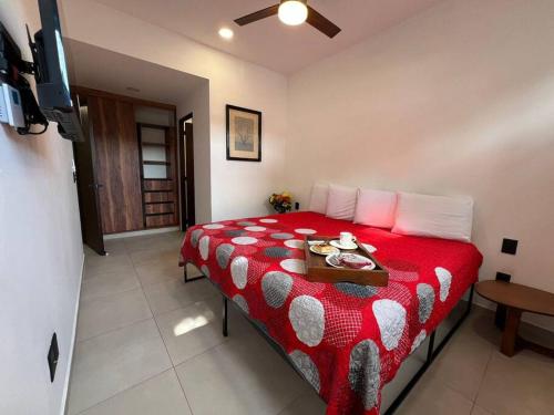 a bedroom with a red bed with a tray on it at Céntrico Estudio Con Roof Top Zona Romántica 502 in Puerto Vallarta