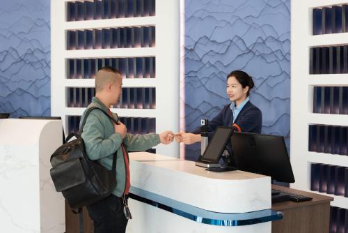 a man and a woman shaking hands at a desk at Holiday Inn Express Yinchuan Lanxi Valley Plaza by IHG in Yinchuan