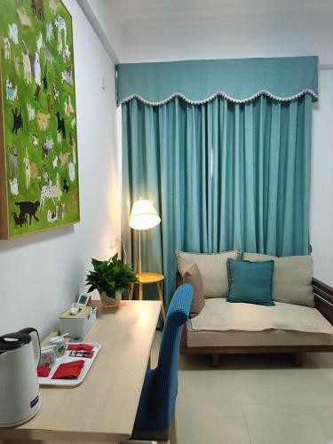 a living room with a table and a couch in front of a window at 小红马民宿 in Yinzhan'ao