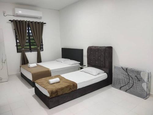 a bedroom with two beds and a window at Sofia roomstay in Kijal