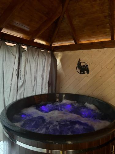 a hot tub in a room with a sign on the wall at U Topora z Jacuzzi - 80m do stacji narciarskiej in Małe Ciche