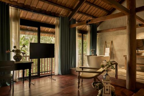 a living room with a television and a table and a couch at aNhill Boutique in Hue