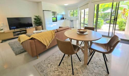 a living room with a couch and a table at Noosa River Retreat Holiday Apartments in Noosaville