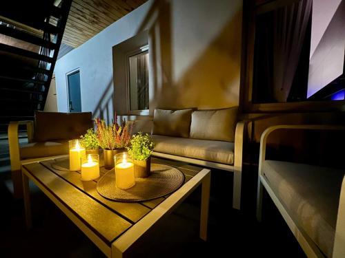 a living room with a couch and candles on a table at Newly Renovated 1BR in Kaunas Downtown Central Location Fast WiFi in Kaunas