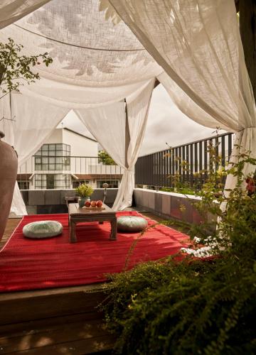 a living room with a table on a red rug at aNhill Boutique in Hue