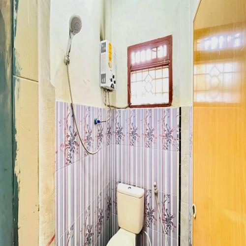 a bathroom with a toilet and a shower at RedDoorz at Serdika Pavilion Berastagi in Berastagi