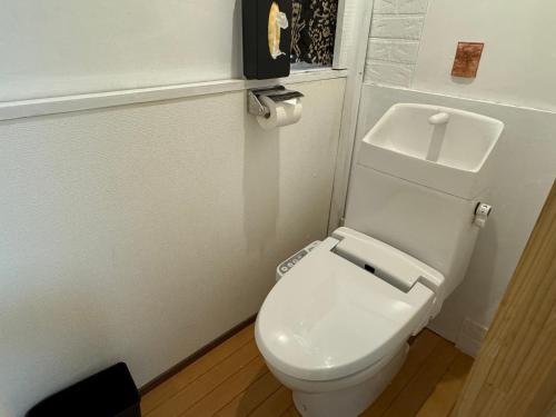 a bathroom with a white toilet in a room at ゲストハウス千福 in Saga