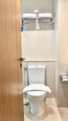 a bathroom with a toilet with two towels on top at Cordela Senen Jakarta in Jakarta