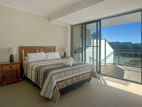 una camera da letto con un letto e un balcone di Unit 19 - Avoca Palms Resort ad Avoca Beach