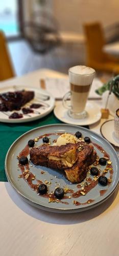 Un plato de comida en una mesa con una taza de café. en Hotel Siesta, en Świebodzin