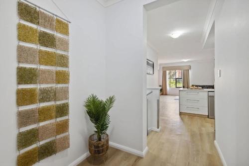 a kitchen and living room with white walls and a plant at 3BR Oasis Townhouse in Northbridge in Perth