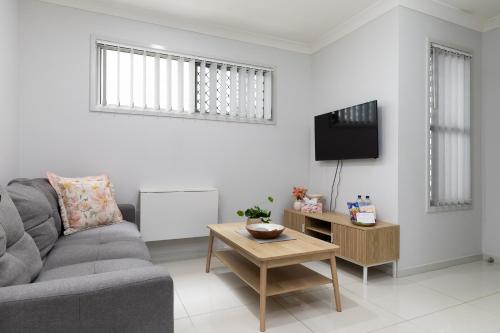 a living room with a couch and a table at Smart Suites Self Check-in Apartments - Freney Park in Brisbane