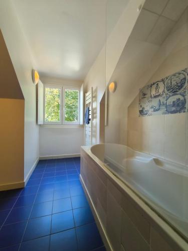 a large bathroom with a tub and a window at Le Peyret in Serres-Castet