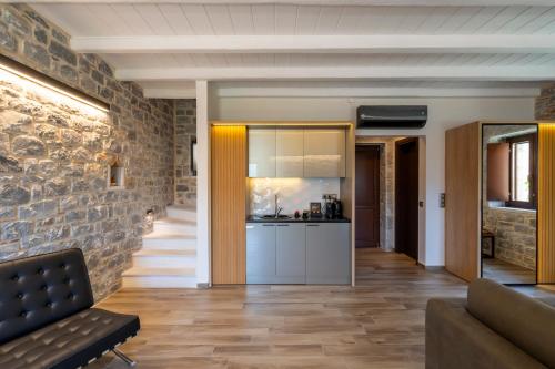 a kitchen and living room with a stone wall at Manifest Boutique Hotel in Oítilon
