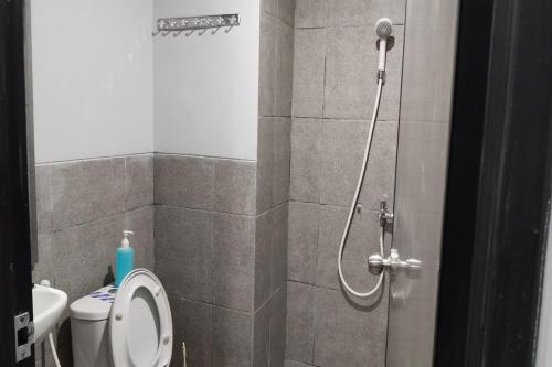 a bathroom with a shower with a toilet and a sink at Riverdale Cikarang by Veto Rooms in Tanahbaru