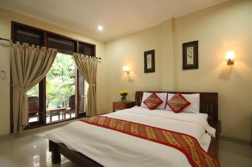a bedroom with a large bed and a window at SURFARIS INN on poppies 2 in Legian