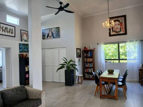 a living room with a table and a ceiling fan at Coastal Retreat Holiday Home Rarotonga in Oneroa