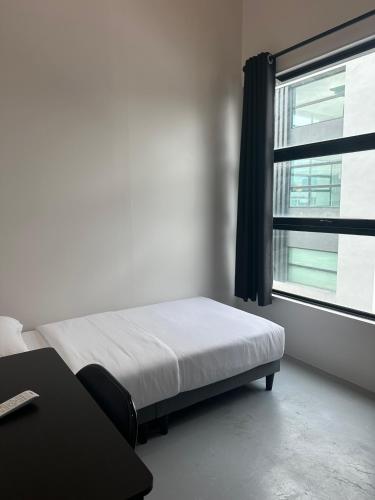 a bedroom with a bed and a window at Be Right Back Loft - Alma in Kampong Ayer Merah