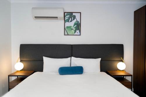 a bedroom with a bed with a blue pillow on it at Littomore Suites Bathurst in Bathurst