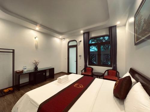 a bedroom with a large bed and two chairs at La Mai Tam Coc Homestay in Ninh Binh