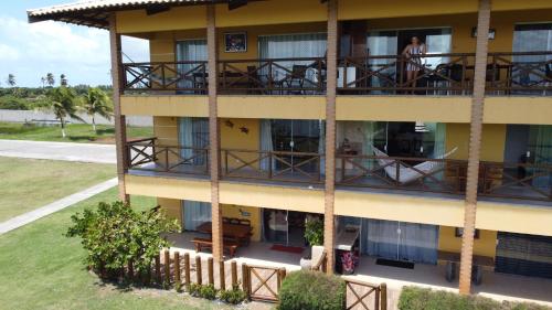 an apartment building with a balcony with people on it at Villa das Águas o Paraiso in Praia do Saco