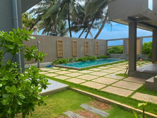 a backyard with a swimming pool and a house at Villa Sea Queen in Ambalangoda