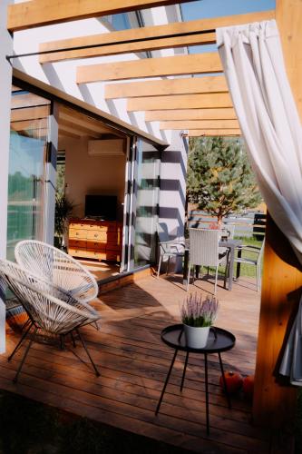 a wooden deck with chairs and a table at Osada pod Gwiazdami & SPA - FAMILY ogrodzony dom, prywatne JACUZZI, kominek, grill, ognisko, Kajaki, Plaża, Jeziora in Łasko