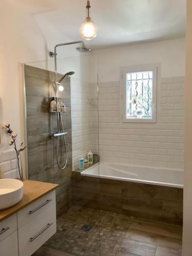 une salle de bain avec une baignoire, une douche et un lavabo dans l'établissement Villa avec piscine proche de Nîmes et Montpellier, à Sardan