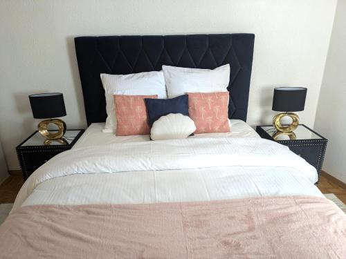 a large bed with two lamps on either side of it at Montreux Central Boutique Apartment Lake View and Terrace in Montreux