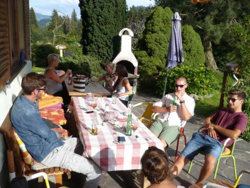 a group of people sitting around a table on a patio at Hotel Garni Wieshof in Kirchberg in Tirol
