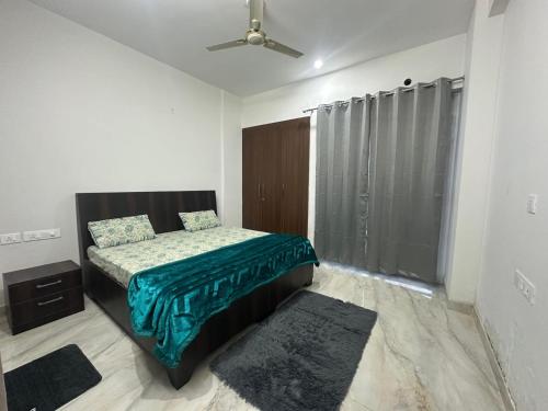 RājpurThe GreyDen的卧室里有一张床，上面铺着绿色毯子