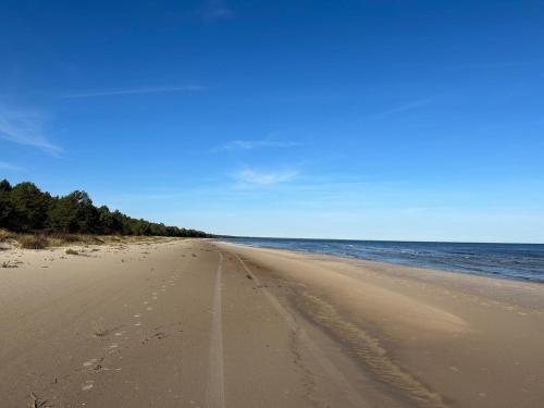 a sandy beach with a view of the ocean at Brīvdienu māja Mulki in Ģipka