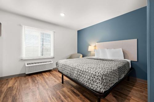 a bedroom with a bed and a window at WoodSpring Suites Huntsville - Research Park in Huntsville